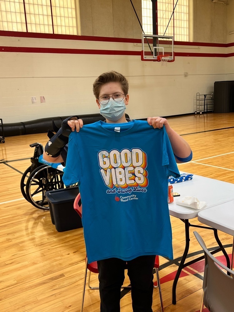 student posing with donation shirt. 