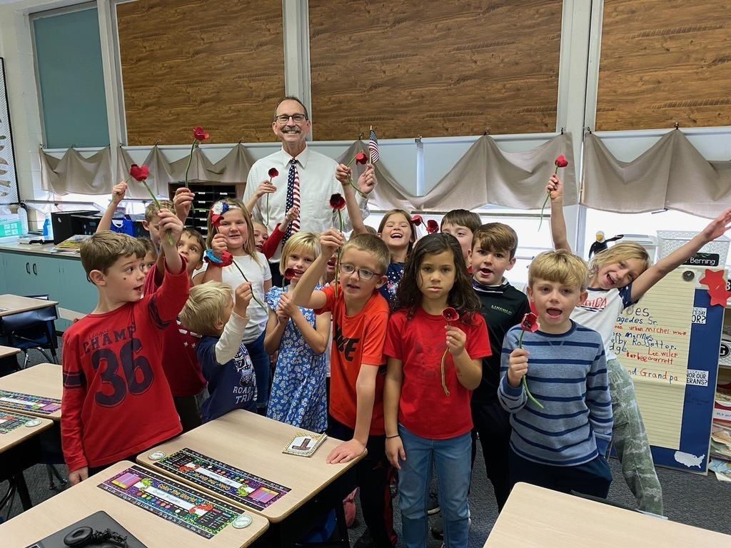 Students made red poppies and show them to Mr. G