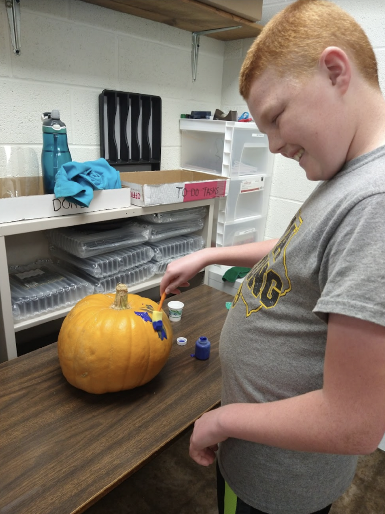 Student painting a pumpkin