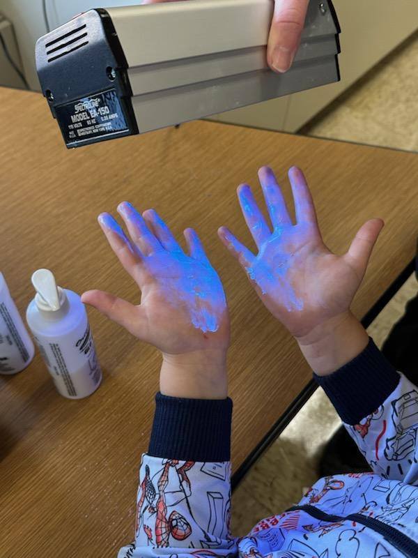 Student hands under UV light