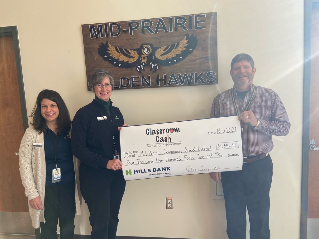 Superintendent and Hills Bank representatives holding donation check