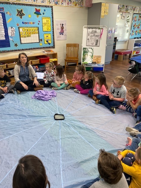 Students sitting in a circle for Rainbow Dance