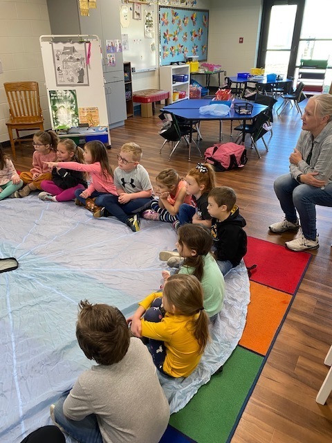 Students sitting in a circle for Rainbow Dance