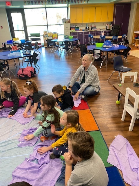 Students sitting in a circle for Rainbow Dance