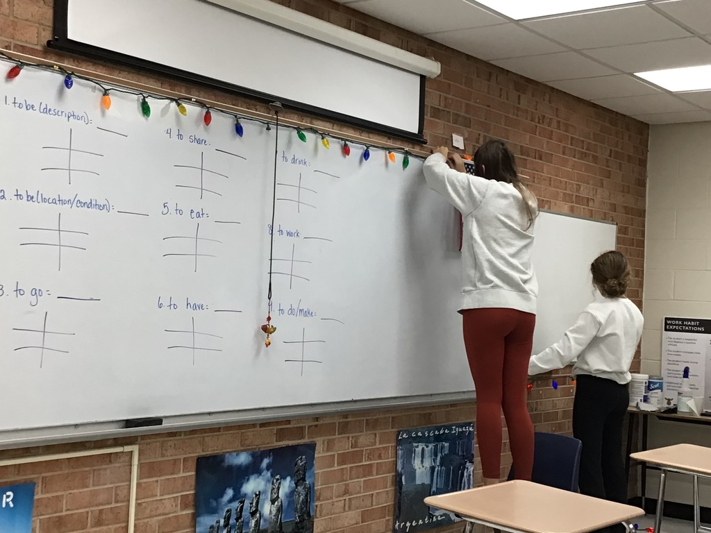 Students hanging up decorations in the classroom