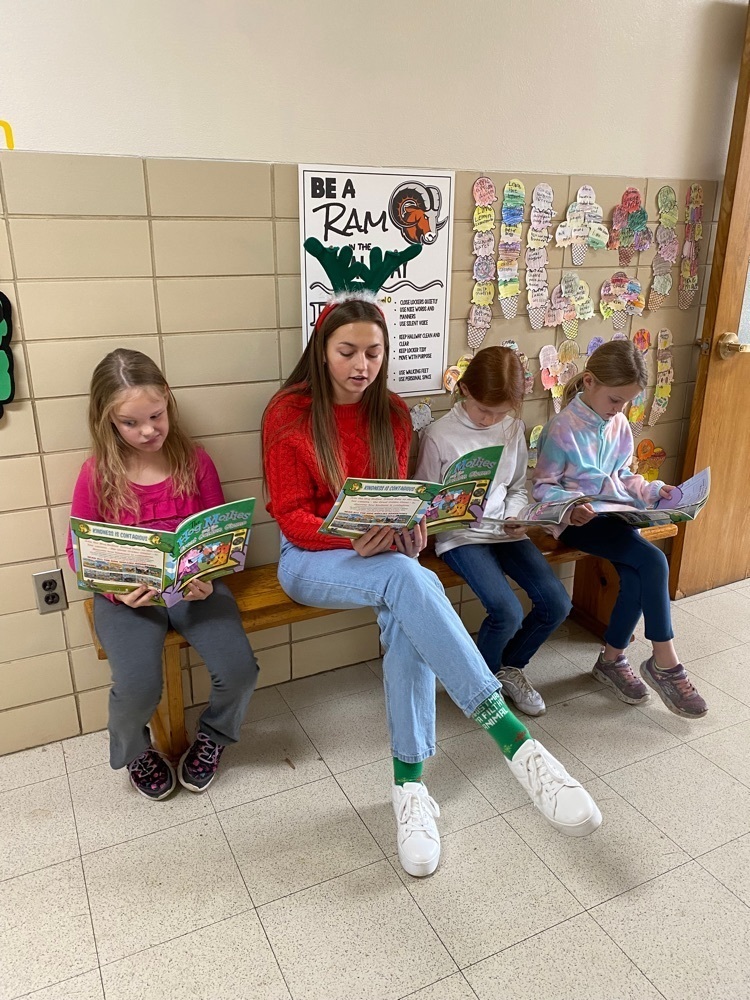 High School student reading to kids.