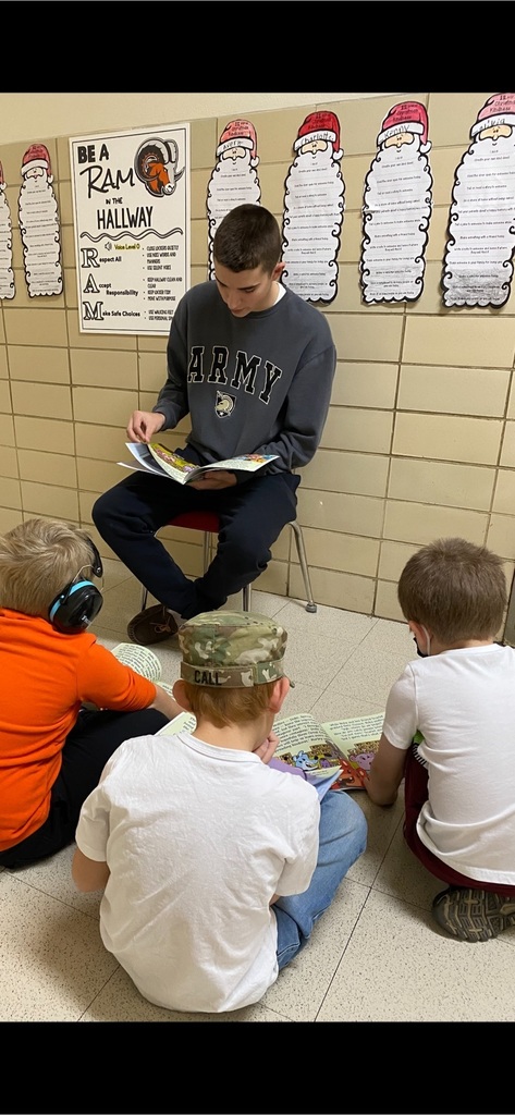 High school student reading to kids.