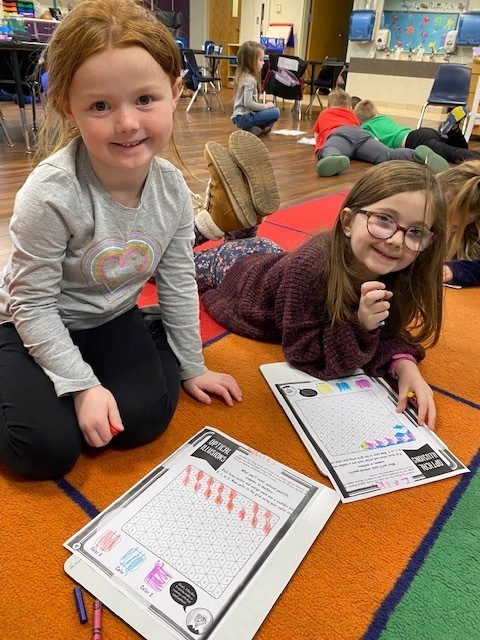 Kindergarten students coloring an optical illusion paper