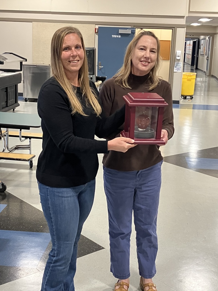 Michelle Larson passing the red apple to Mrs. C.