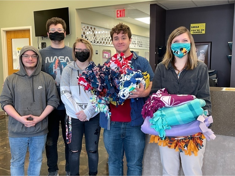 students posing with blankets