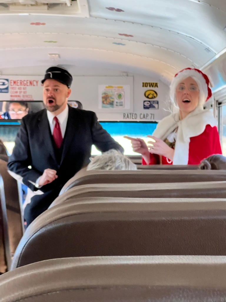 Mr. Slabaugh dressed as the conductor and Mrs. Hunter dressed as Mrs. Claus on the bus