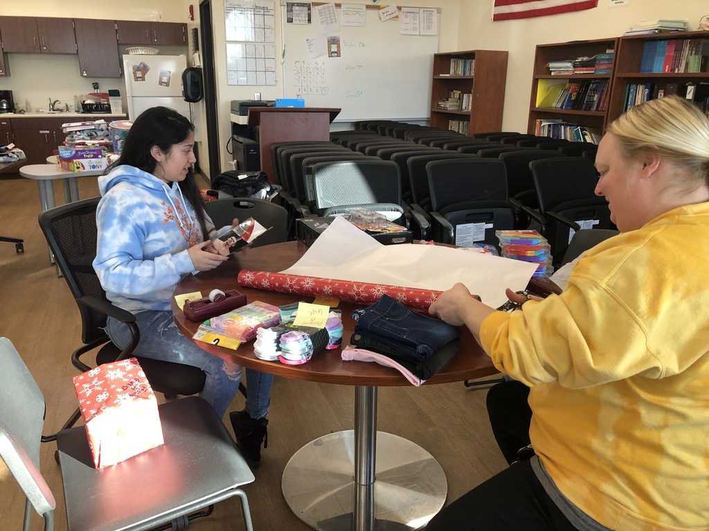 Student and staff member wrapping gifts