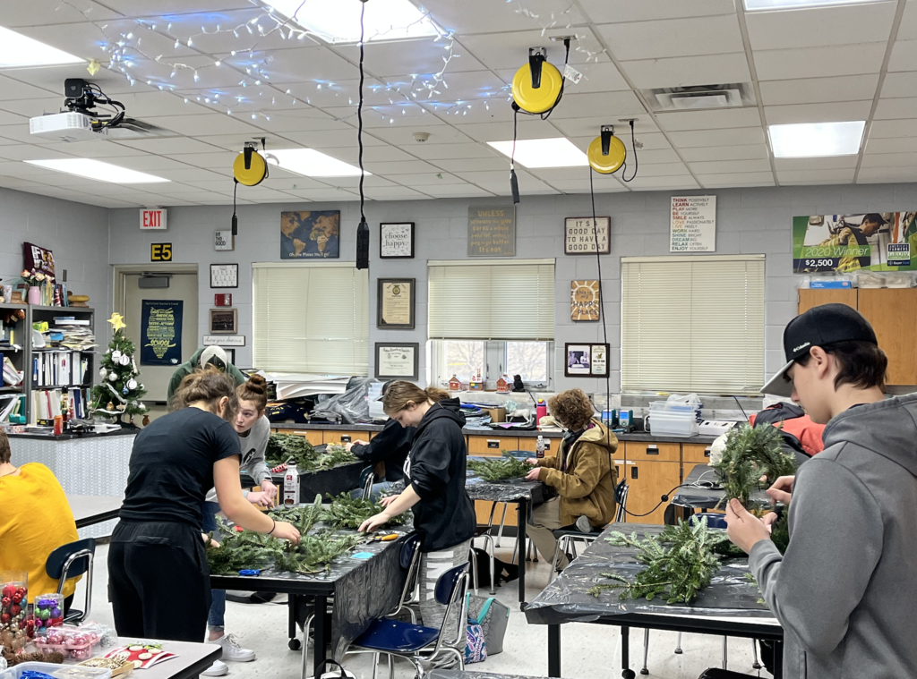 Students building holiday wreaths