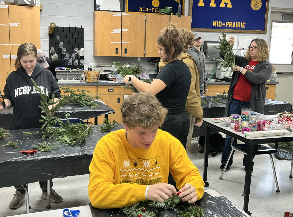 Students building holiday wreaths