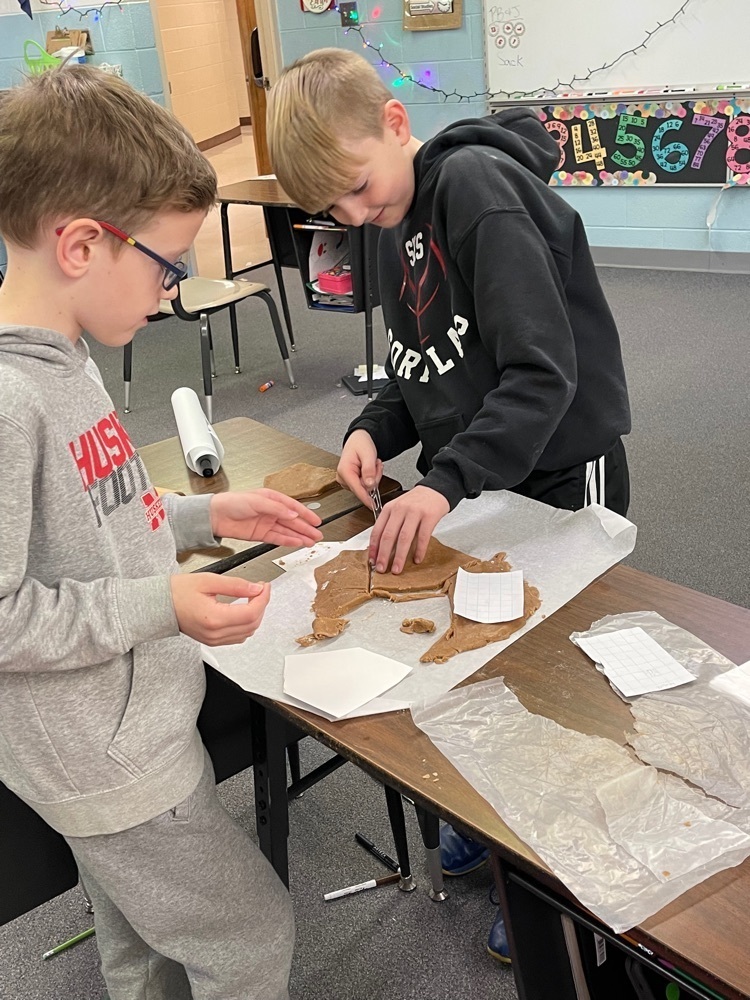 working together to cut out their ginger bread house pieces