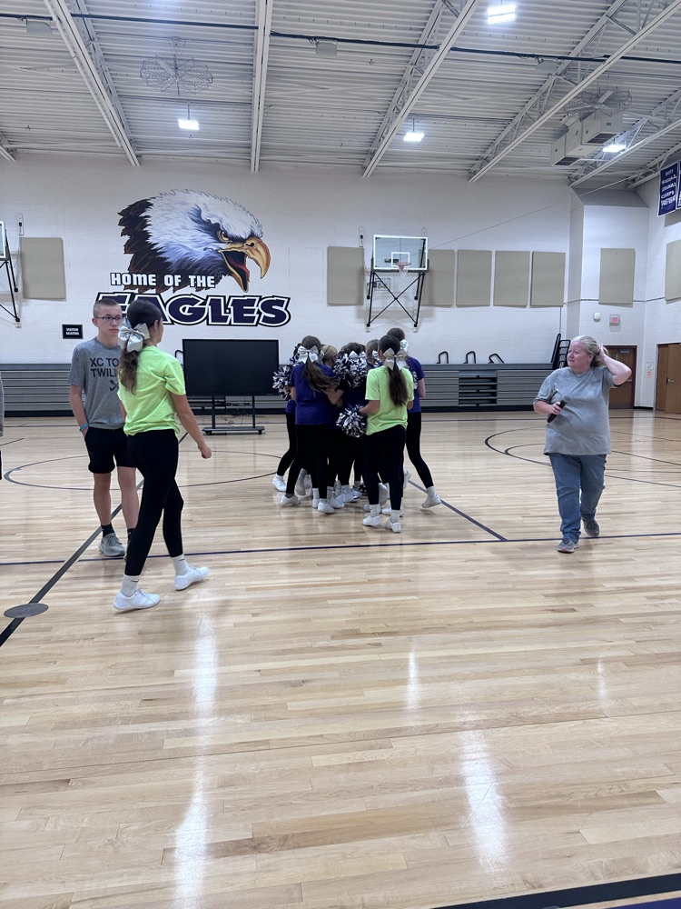 the cheerleaders giving on of their own - Willa - a good luck hug