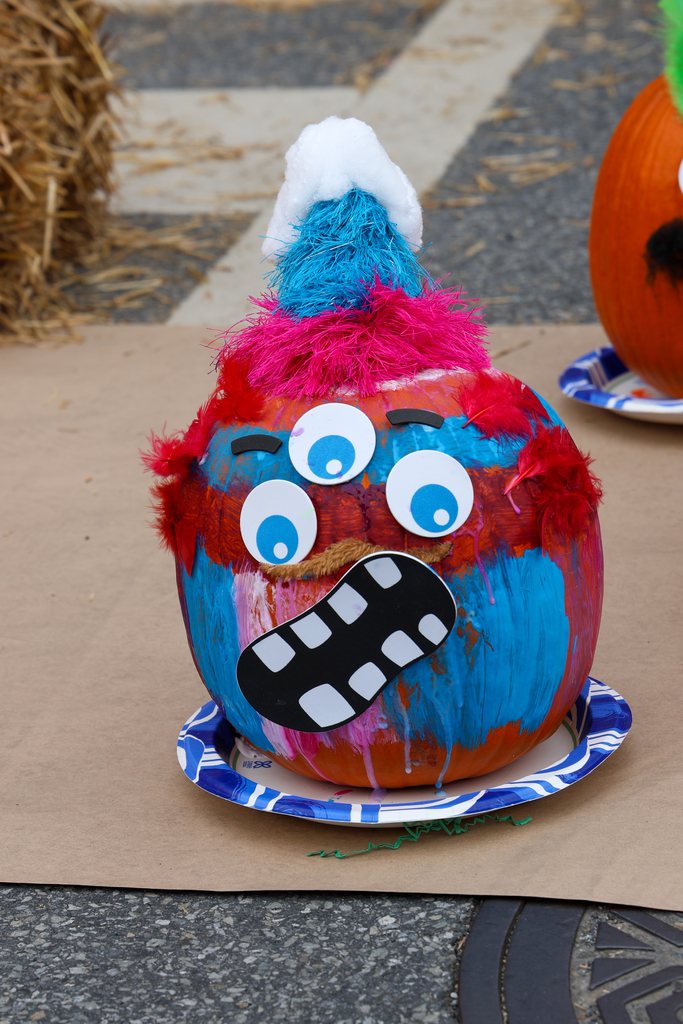 pumpkin decorated with three eyes and a silly mouth