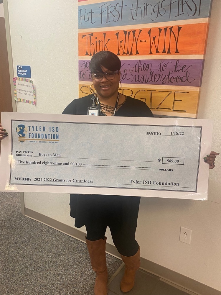 teachers posing with large check