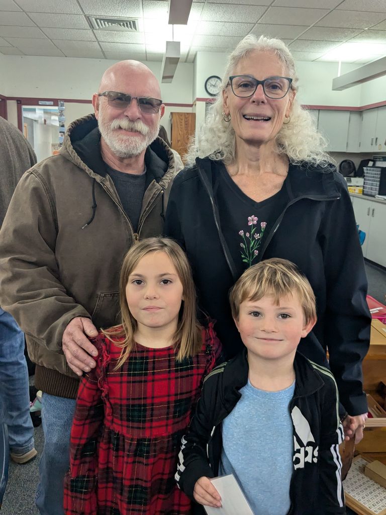 Children and grandparents smiling in the classroom.
