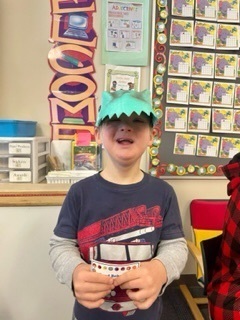 male student with a dinosaur hat