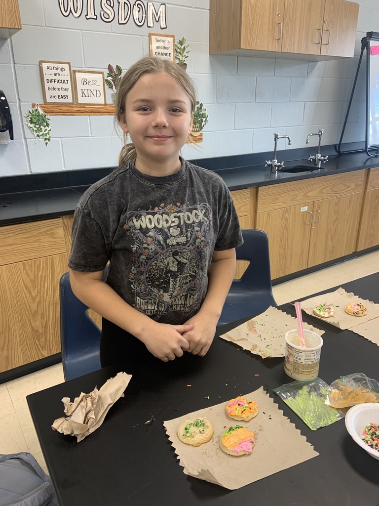 Student showing frosted cookies.