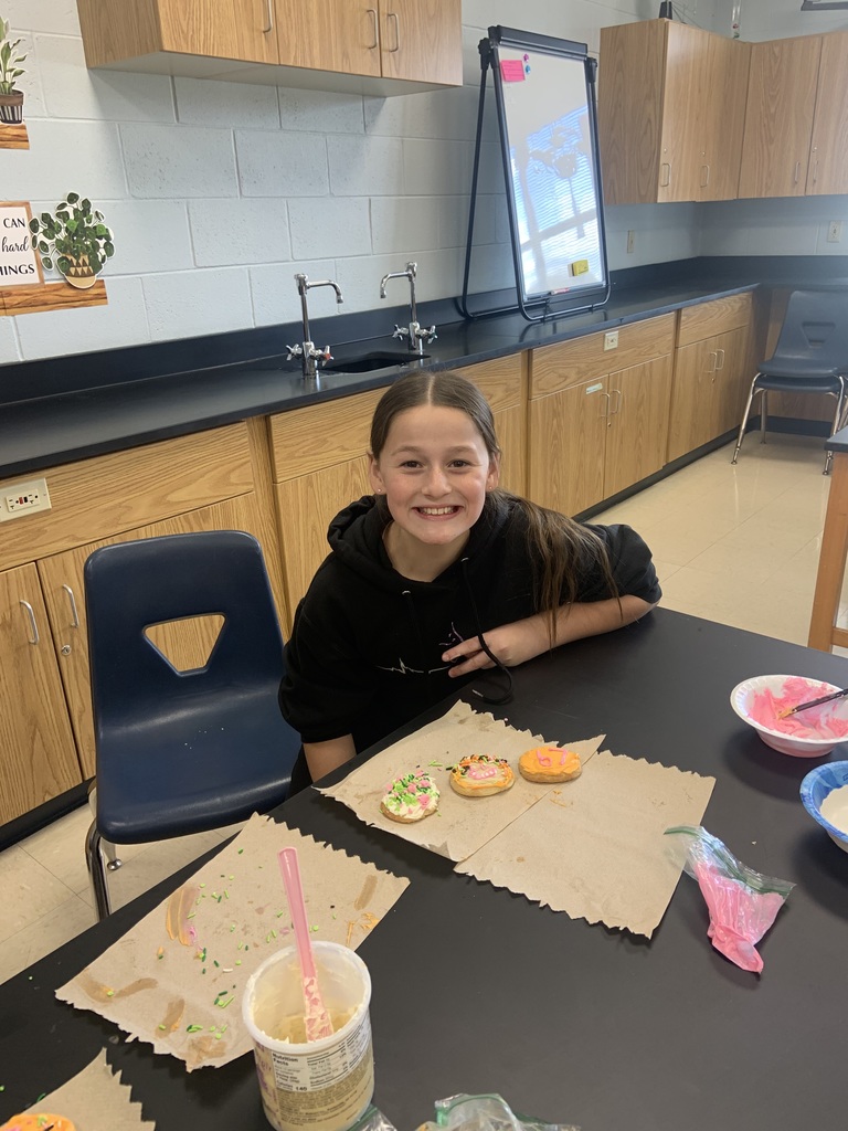 Students showing off frosted cookies.