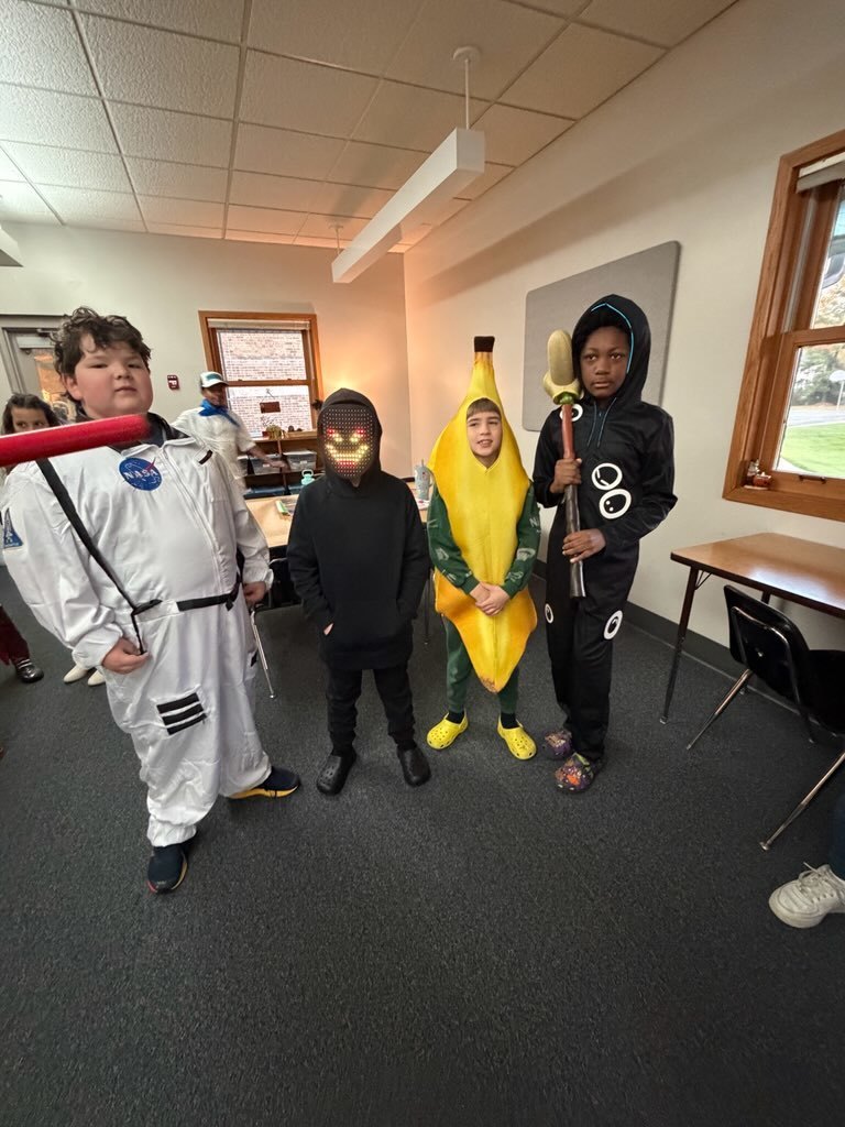 4 Upper El students in costumes on Halloween: astronaut, ninja, banana