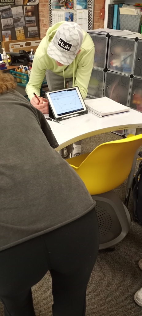 Students working on writing geometry transformation sentences
