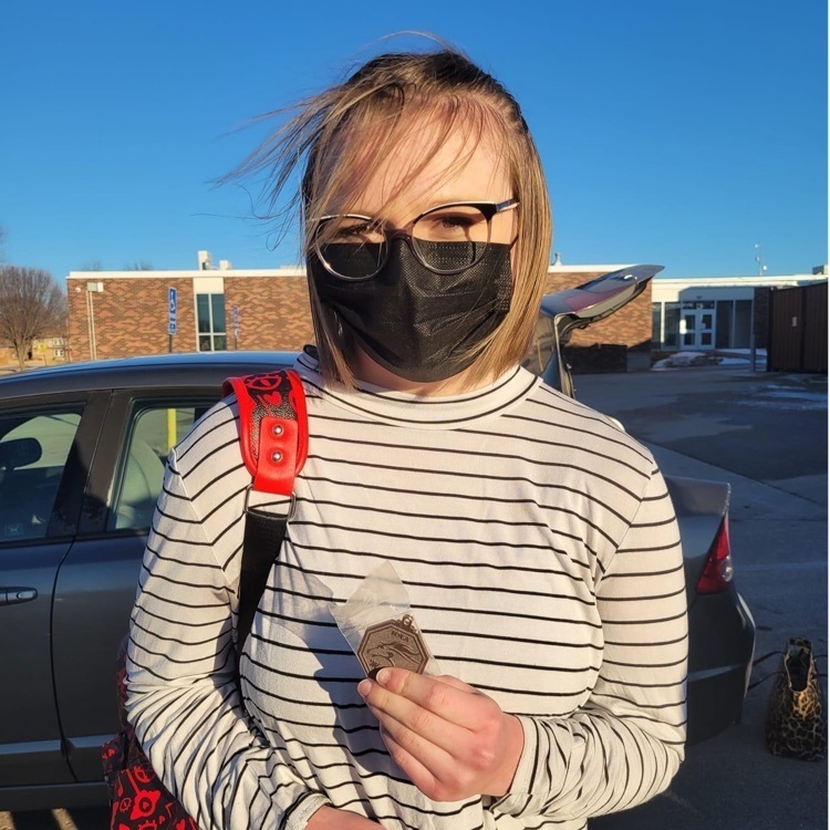 student posing with a medal