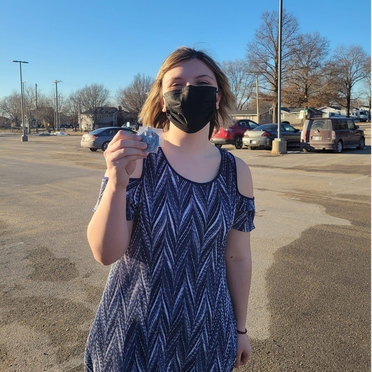 student posing with a medal