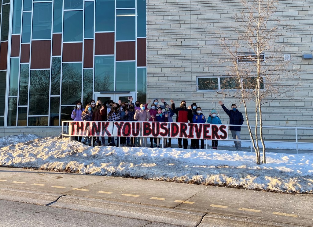 Kromrey Students holding a sign that says "thank you bus drivers"