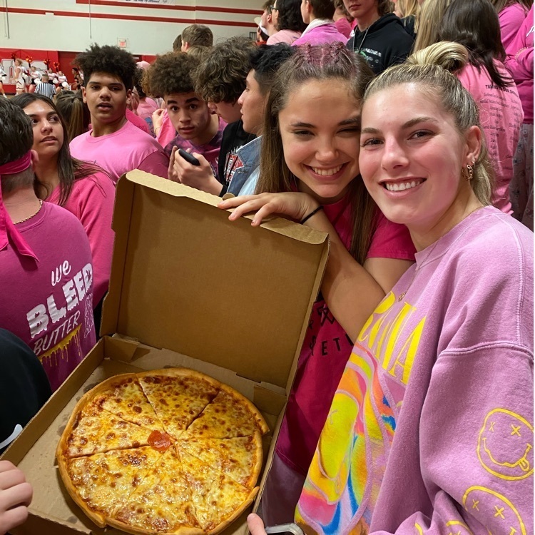 students posing with pizza