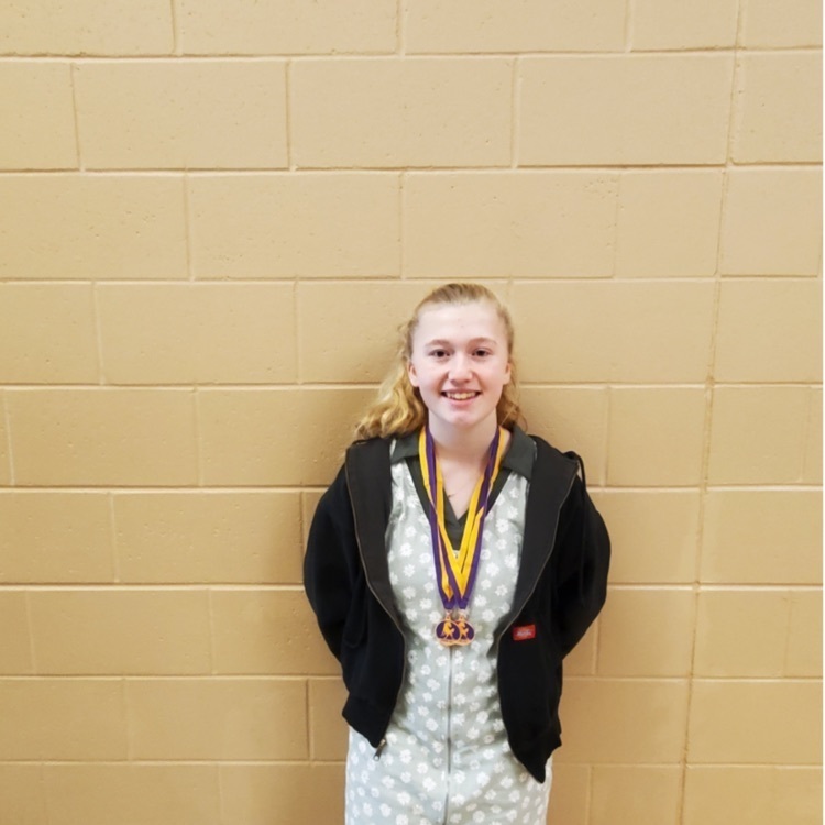 student posing with medals