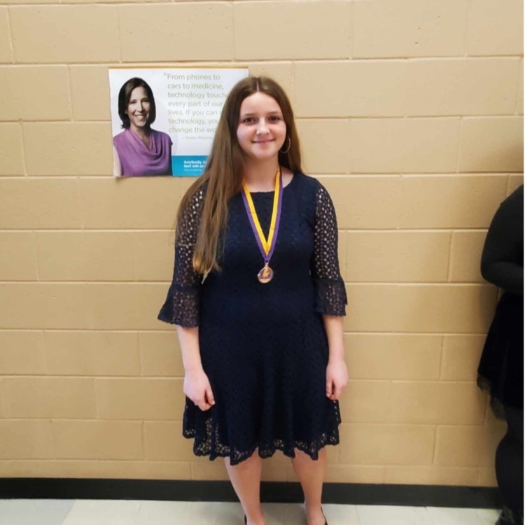student posing with a medal