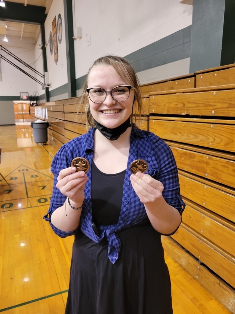 student posing with a medal 