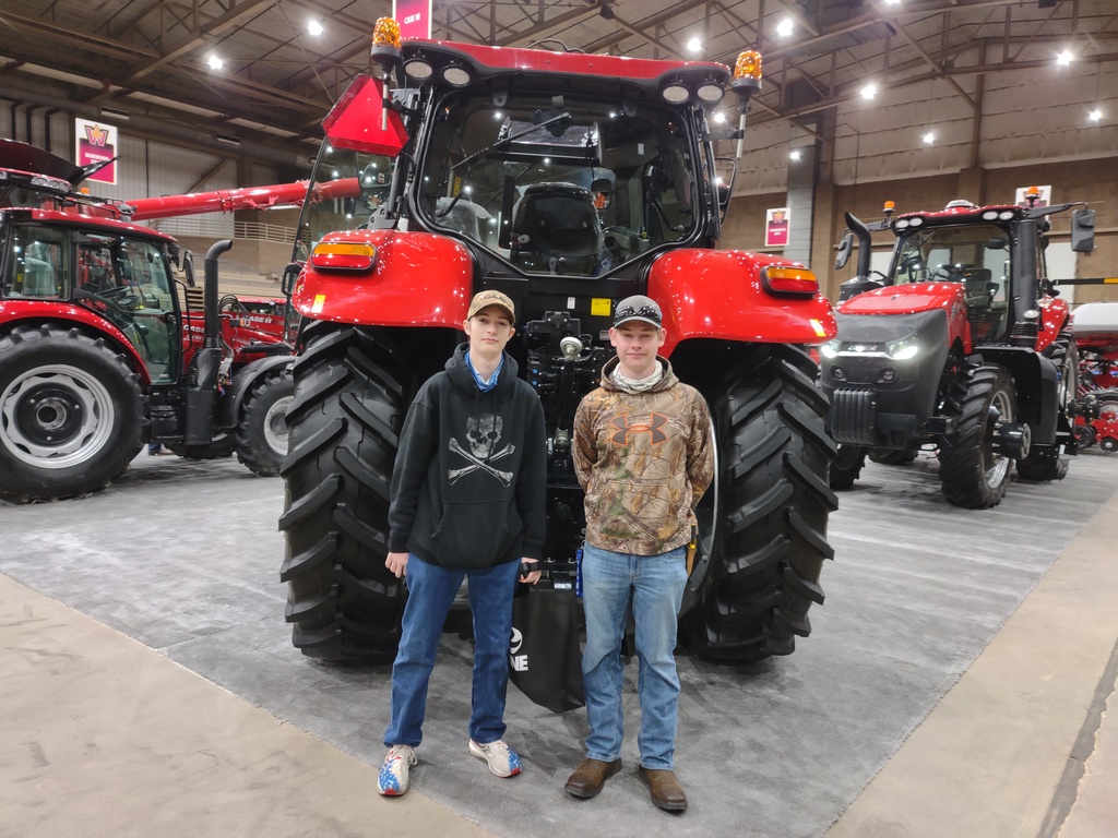 two students posing in front of a tracker