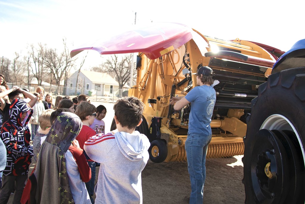 Grade School students learn about a baler from a high school FFA student..