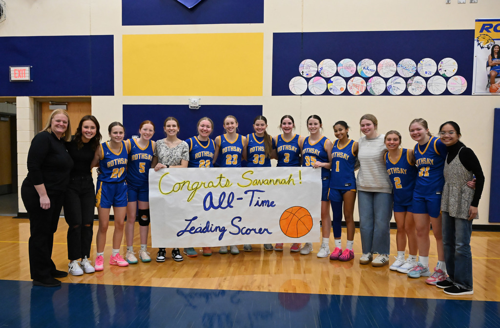 The varsity team and Mrs. Heier with a poster of congratulations. 