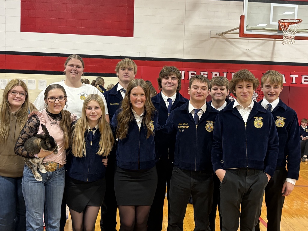 Many of the students are wearing navy blue corduroy jackets with an embroidered emblem, which appear to be FFA (Future Farmers of America) jackets, along with white shirts and dark pants or skirts.
