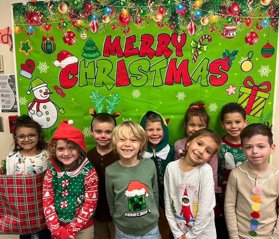 students in front of a Christmas bulletin board