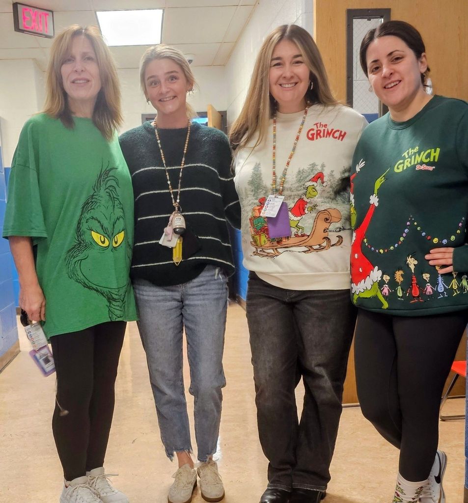 Four women in holiday clothing, smiling.