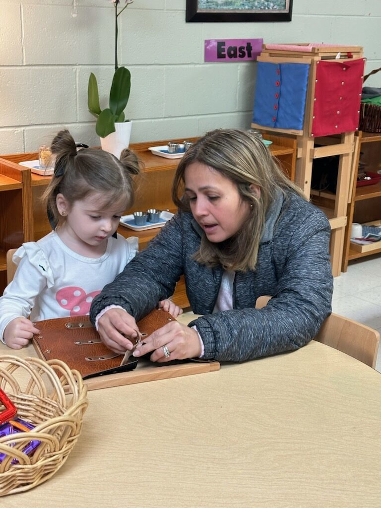 teacher guiding a child to buckle