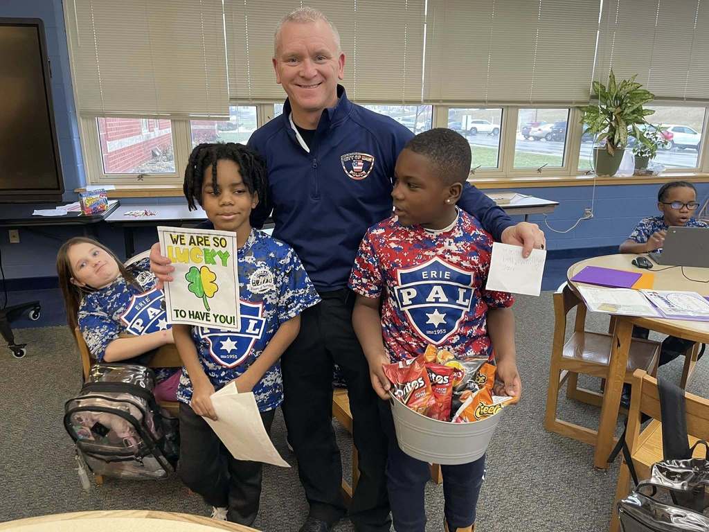Two students standing with a Police Officer.