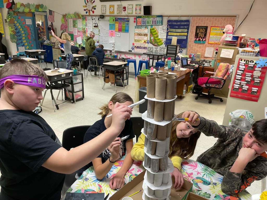 Students posing with and building their Leaning Tower of Pisa projects.