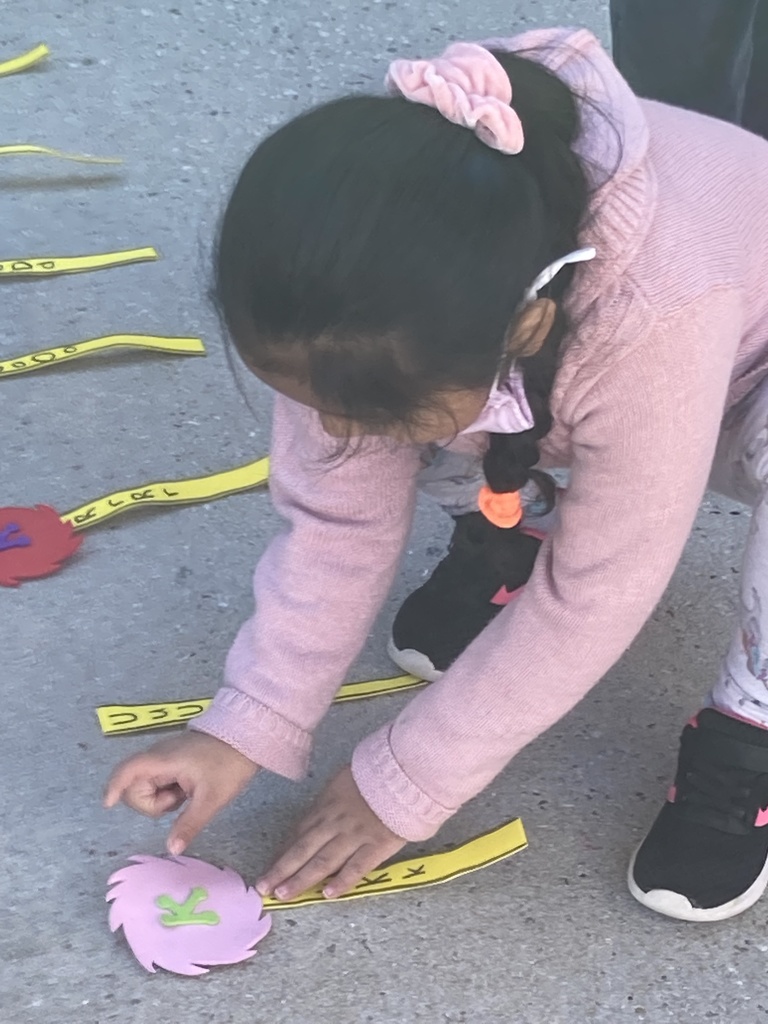 A little girl is matching letters to make a Lorax tree.