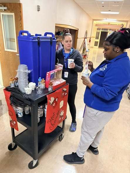 Adults filling their cup of hot chocolate.