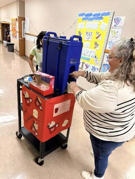 Adult filling their cup of hot chocolate.