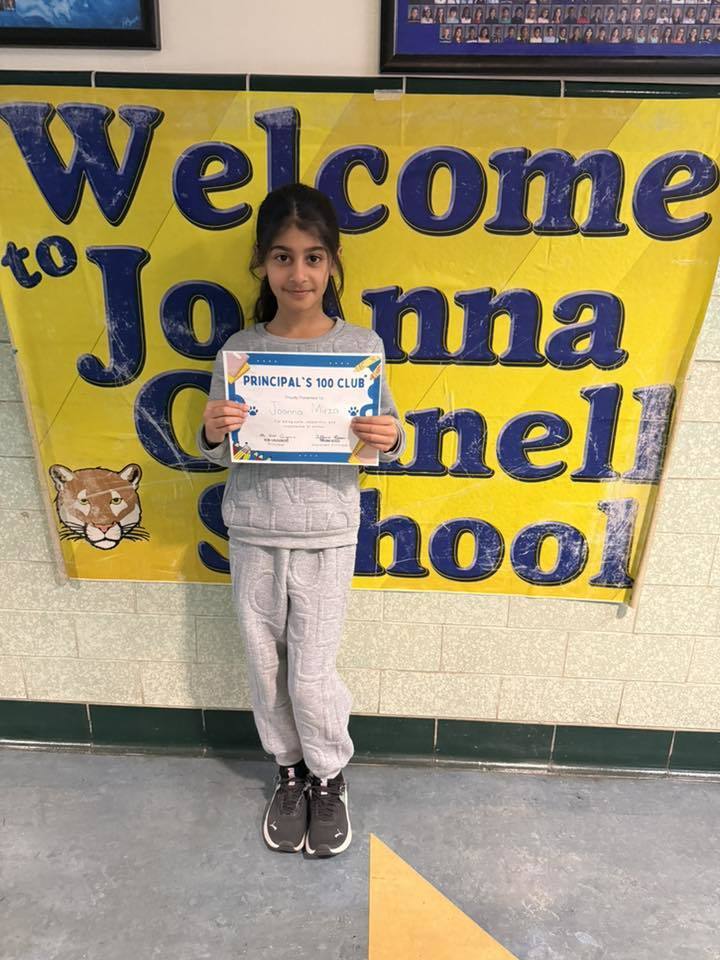 Young girl in all gray and holding her certificate. 