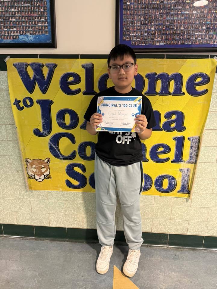 Boy with glasses standing and holding his certificate. 