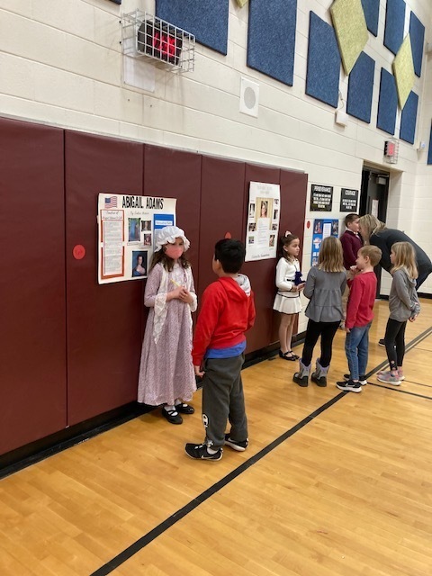 students dressed up as historical figures with other students standing and listening to them talk